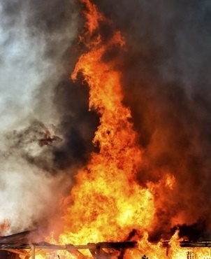 Huge flames coming from a factory on fire in an industrial area.